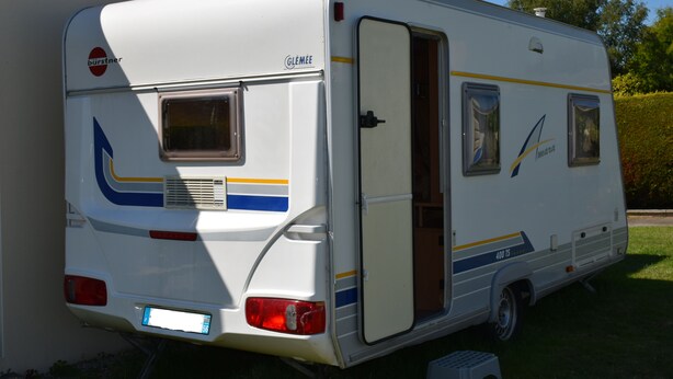A white RV with a rear door open, displaying a compact kitchen area and a small window. - Caravan rental region Guidel(56520) (Guidel)
