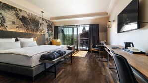 Una habitación de hotel moderna con una cama grande, un escritorio y vistas a la ciudad.