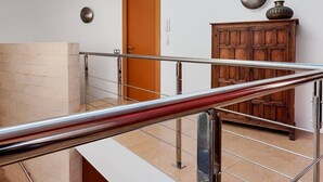 Un interior moderno con una escalera, un armario de madera y una puerta.