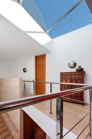 A modern interior with a staircase, a wooden cabinet, and a door. - LA MEVA LLUNA, Luxury villa on the beachfront with pool (L'Ampolla)