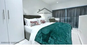 Un dormitorio moderno con cama, escritorio y armario.