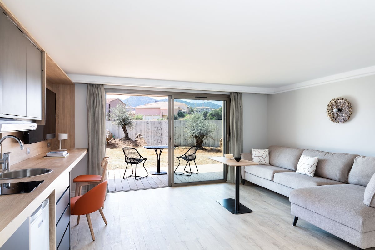 A modern apartment with a kitchen, dining area, and a sofa.
