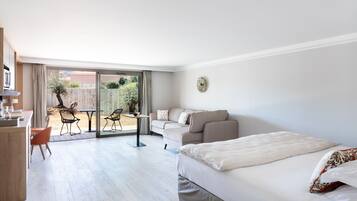 Une chambre d’hôtel moderne équipée d’un grand lit, d’un canapé, d’une table à manger et d’un coin cuisine.