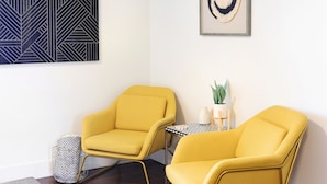 A room with two yellow armchairs, a small table with a plant, and a framed artwork on the wall. - Summit Lofts, Mt Shasta, 2 Queen Beds #209 (Mt Shasta)