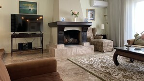 A living room with a fireplace, a television, and a patterned rug. - Athens Neos Kosmos Penthouse, city center & sea view (Athina)