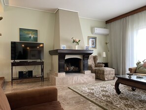 Een smart-tv, een open haard, boeken en een stereo