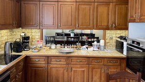 A kitchen with wooden cabinets, a stove, a coffee maker, and various kitchen appliances. - Athens Neos Kosmos Penthouse, city center & sea view (Athina)