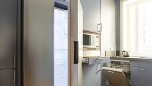 Eine moderne Küche mit Einbau-Mikrowelle, Geschirrspüler und einem Fenster mit Jalousien.