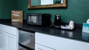 Eine Küchenarbeitsplatte mit einer Mikrowelle, einer Kaffeemaschine und einem Schild mit WLAN-Informationen.