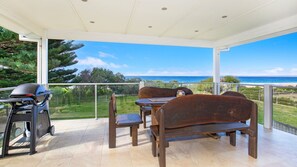 A covered outdoor seating area with a view of the ocean.