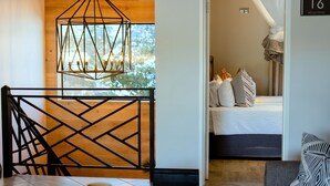 A modern room with a geometric metal partition, a bed with multiple pillows, and a "No Smoking" sign. - Nkosi Guest Lodge (Victoria Falls)
