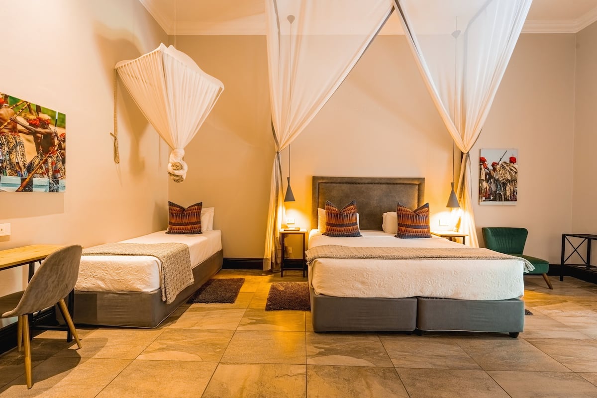 A double room with two beds, a desk, and a chair.