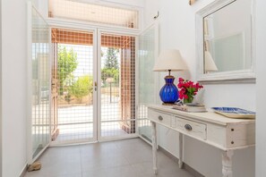 A room with a white dresser, a blue lamp, and a vase with flowers. - Harmony Villa by Fidalsa (Daya Vieja)