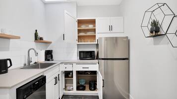 Fridge, microwave, coffee/tea maker, cookware/dishes/utensils