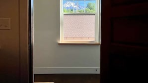 A room with a window overlooking a mountain.
