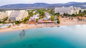 Un resort costero con varias edificaciones, una playa y un mar azul cristalino.