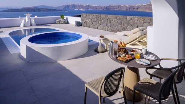 A rooftop terrace with a hot tub, dining area, and a view of the sea. - Acro Blue Luxury Villas (Santorini)