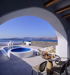 A rooftop terrace with a hot tub, dining area, and a view of the sea. - Acro Blue Luxury Villas (Santorini)