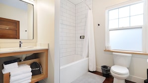 A modern bathroom with a shower, toilet, and vanity.
