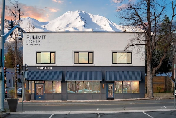 A building named 'Summit Lofts Boutique Hotel' with a 'Theory Coffee' shop on the ground floor.