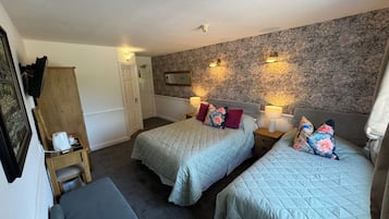A hotel room with two beds, a desk, and a chair.