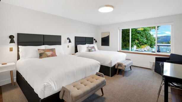 A modern hotel room with two beds, a desk, and a large window offering a view of the outdoors. - Summit Lofts, 2 Queen Beds, Mt Shasta #201 (Mt Shasta)