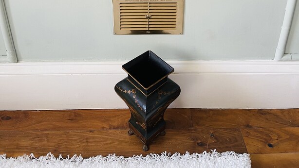 A fireplace with a stone mantle, a metal vent, and a decorative vase. - Charming 2-bedroom Apartment Located in Ayr (Ayr)
