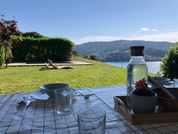 A table set outdoors with a view of a lake and mountains.