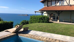 Une maison avec une piscine et vue sur la mer.