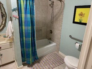 Een badkamer met douche, toilet en wastafel.