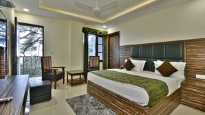 A modern hotel room with a large bed, a desk, and a balcony. - Hotel Comfort Court (Dalhousie)