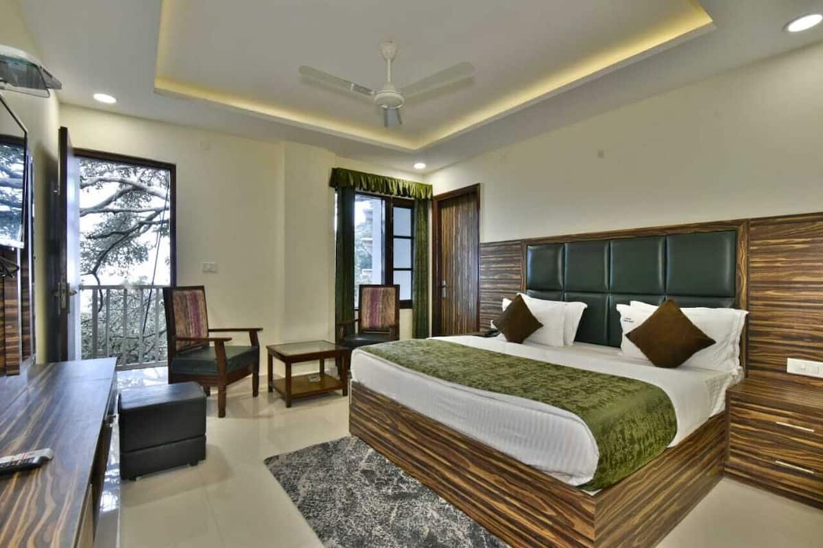 A modern hotel room with a large bed, a desk, and a balcony.
