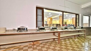 A buffet setup with multiple serving stations and a checkered floor. - Hotel Comfort Court (Dalhousie)