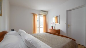Un dormitorio con cama, cómoda, espejo y puerta.