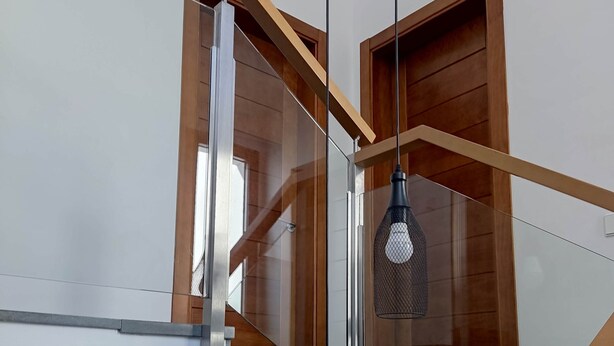 A modern staircase with glass railings and wooden accents, leading to an upper floor. - Casa Marisa, Villa CON Piscina Delante DEL MAR (Les cases de Alcanar)