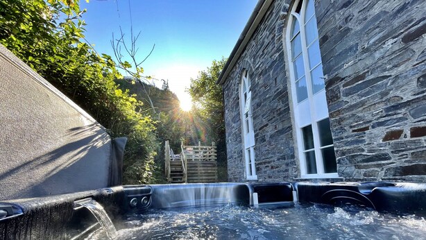 Un bâtiment en pierre doté d’un espace avec un jacuzzi.