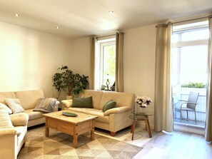 Una sala de estar con un sofá, una mesa de centro y una planta en maceta.