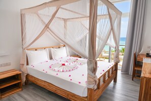 A bed with a canopy, white bedding, and pink flower petals. - AHG Sun Bay Mlilile Beach Hotel (Matemwe)