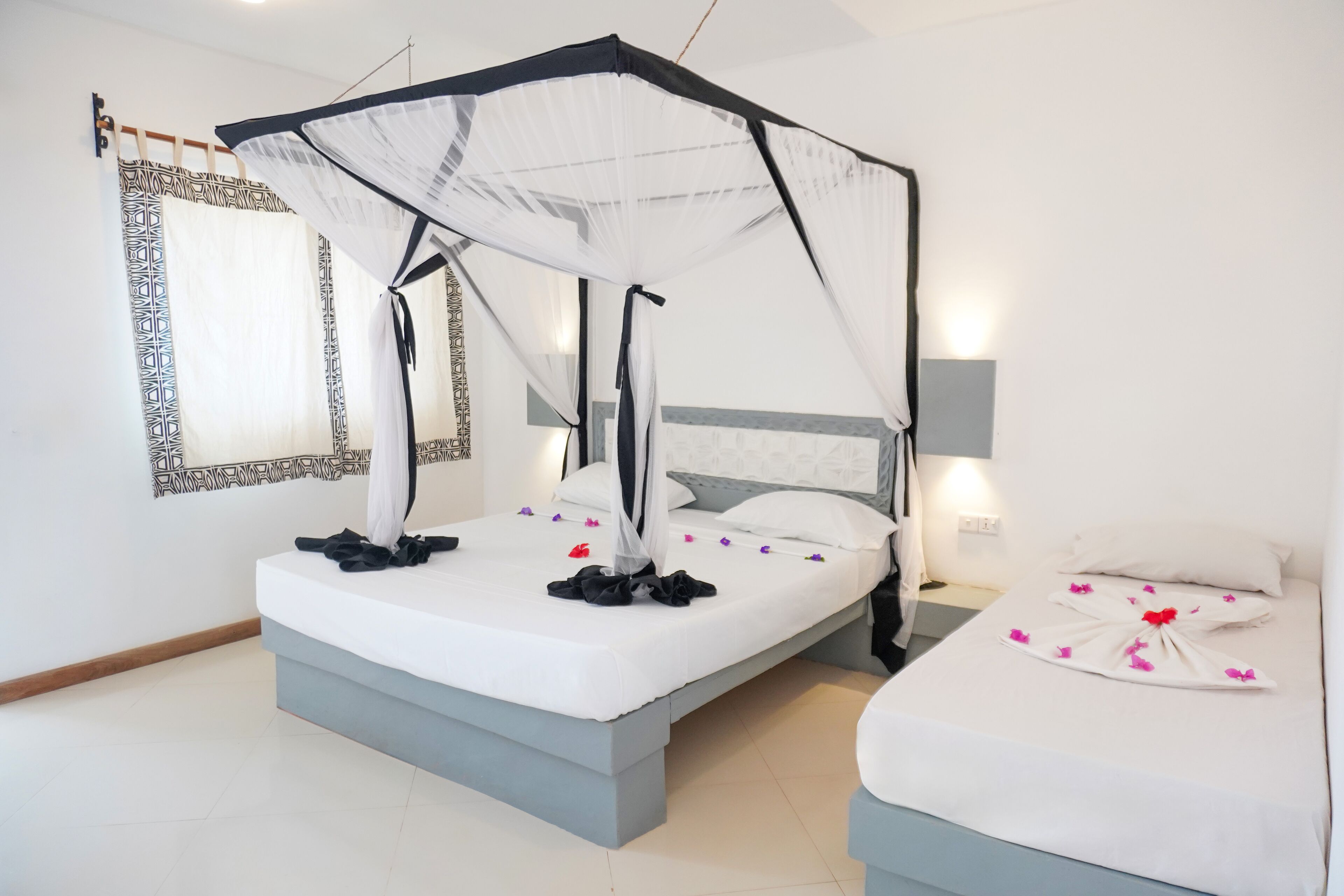 A double bed with a canopy, a bedside table, and a nightstand.