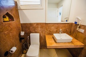 Habitación clásica, 1 habitación, vista parcial al océano, junto a la playa | Baño | Regadera, regadera tipo lluvia, secadora de cabello, toallas 