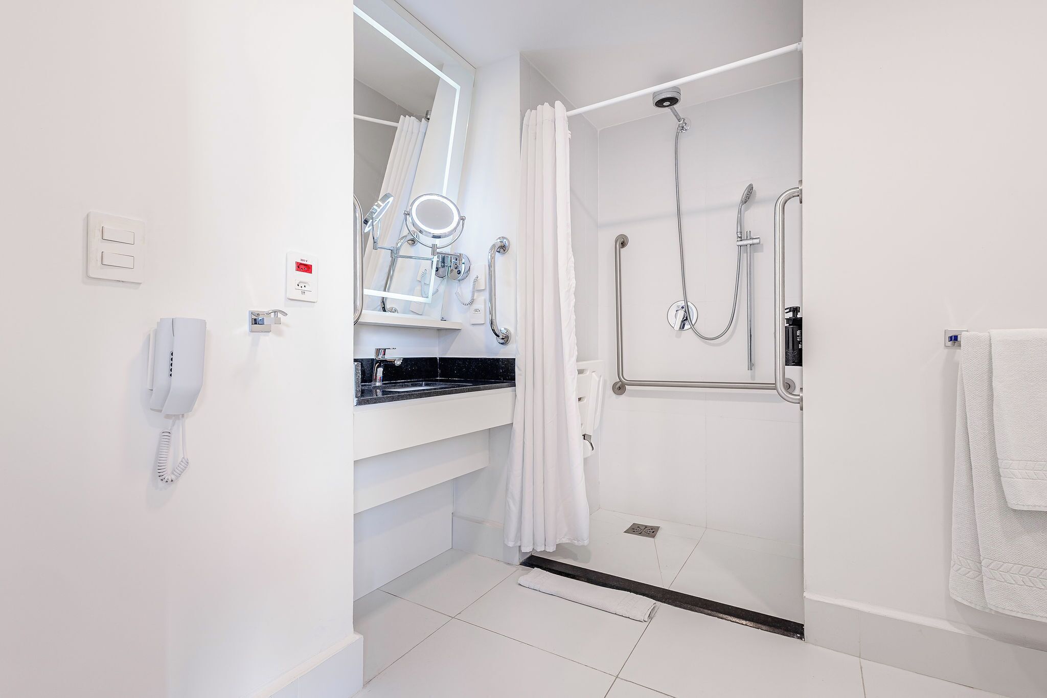 A modern bathroom with a shower, toilet, and sink.