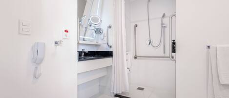 A modern bathroom with a shower, toilet, and sink.