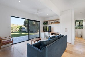 Contemporary living space with a kitchen, flat-screen TV, and seating area.