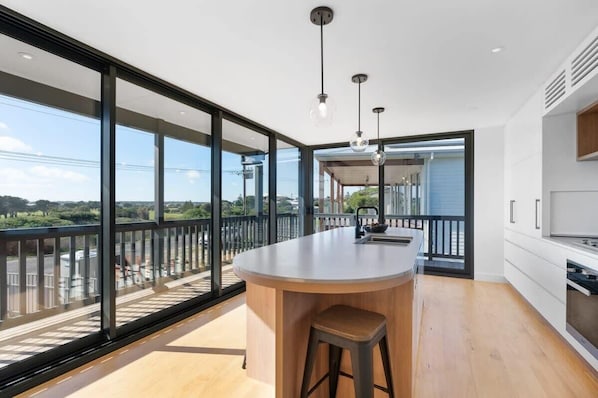 Enjoy a spacious kitchen with a central island, sink, and stove, offering a view of the outdoors.