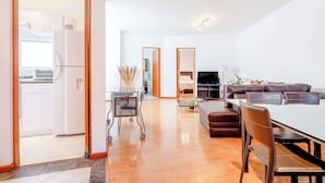 A modern living room with a sofa, TV, and a dining area with a table and chairs. - Upscale Polanco | Steps to Metro, Dining & Parks (Ciudad de México)