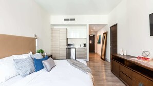 A modern hotel room with a large bed, a small kitchenette, and a wooden dresser. - The Most Liked Homes, Hot tub (Hollywood)