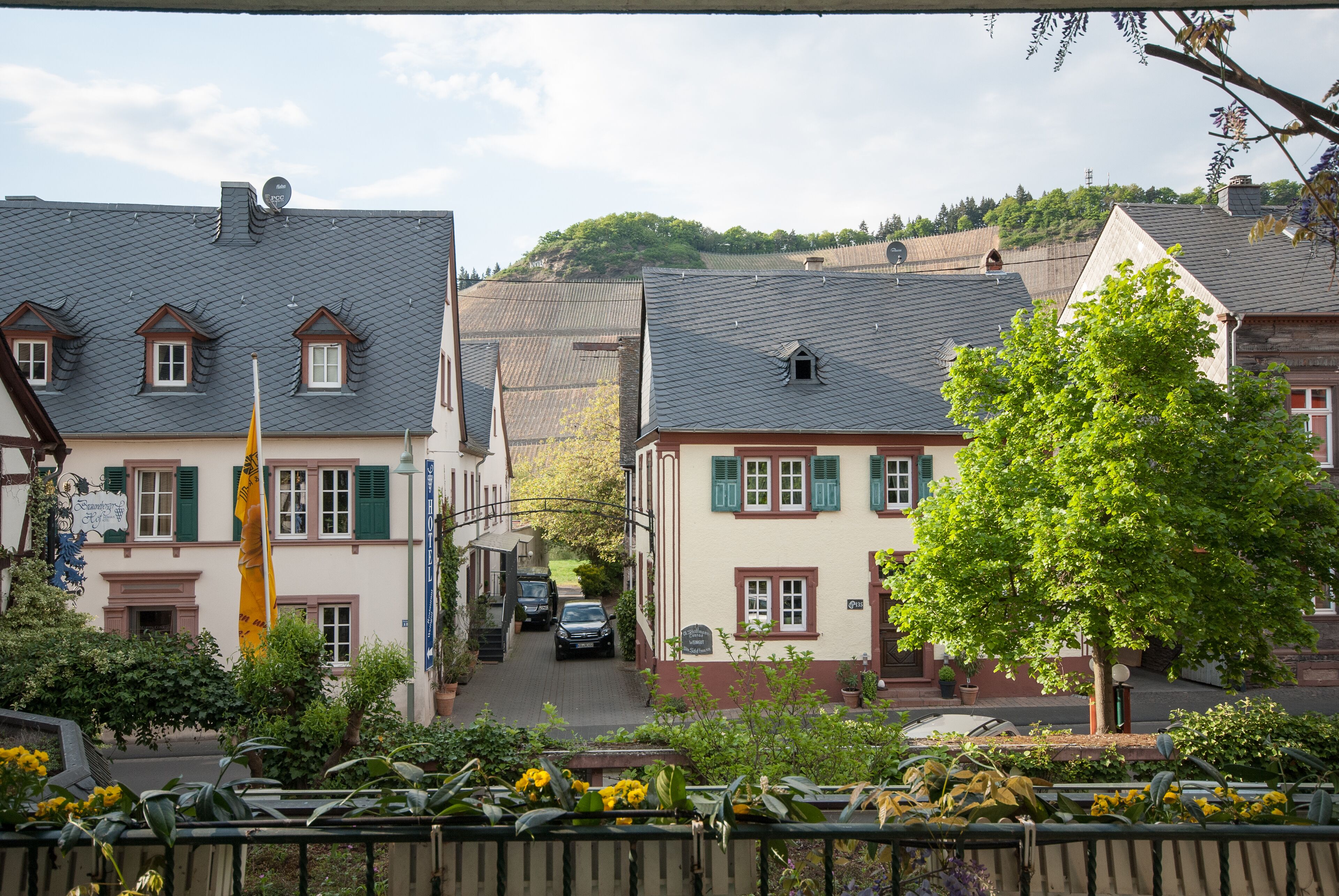 Eine traditionelle europäische Stadt mit engen Gassen, charmanten Gebäuden und einer zentralen, von Bäumen gesäumten Straße.