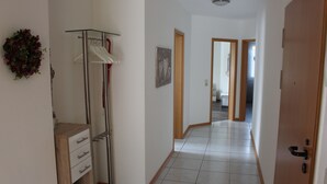 A hallway with a wooden wardrobe, a glass shelf, and a door leading to another room. - The apartment "Loretta" is a modern, quiet and centrally located apartment. (Traben-Trarbach)
