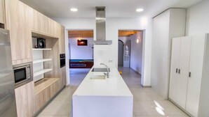 Eine moderne Küche mit Kochinsel, integrierten Geräten und stilvollem Design.