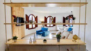 Ein modernes Wohnzimmer mit einem blauen Sofa, Holzböden und Dekorationselementen.